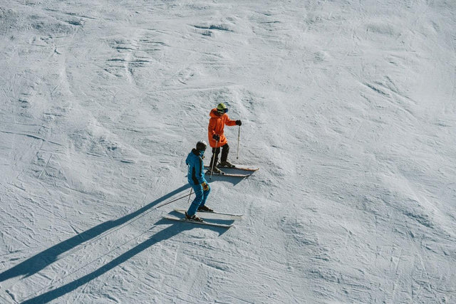 Ski instructor explaining technique to a student on a slope in Baqueira