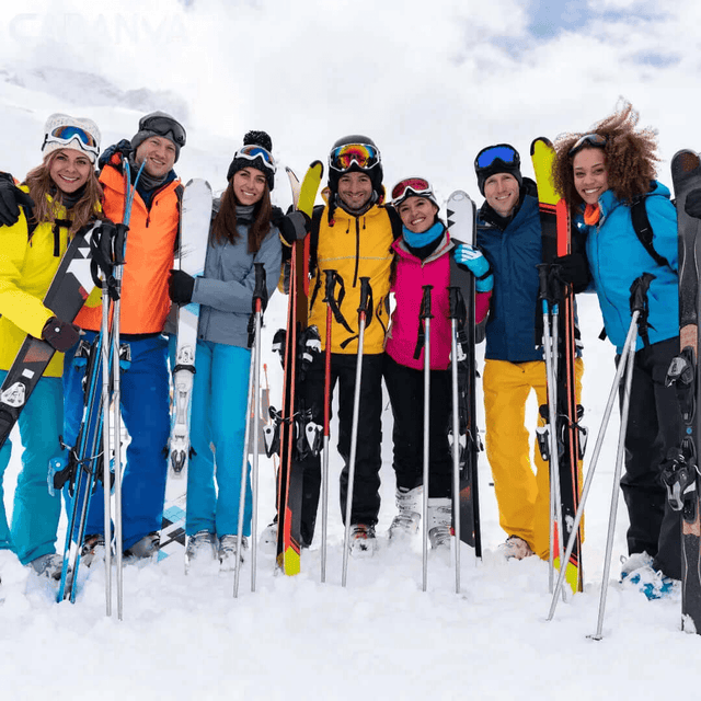 Group of friends smiling in the snow with their skis and poles